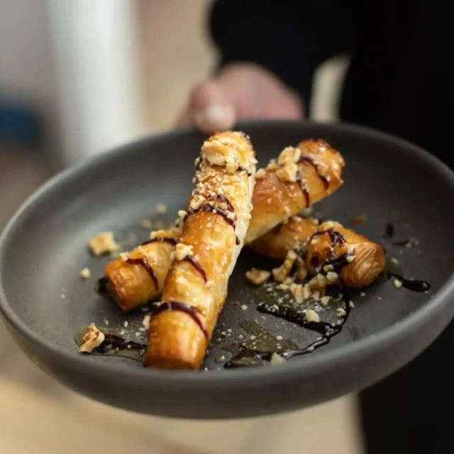 Golden pastries with nuts and sauce